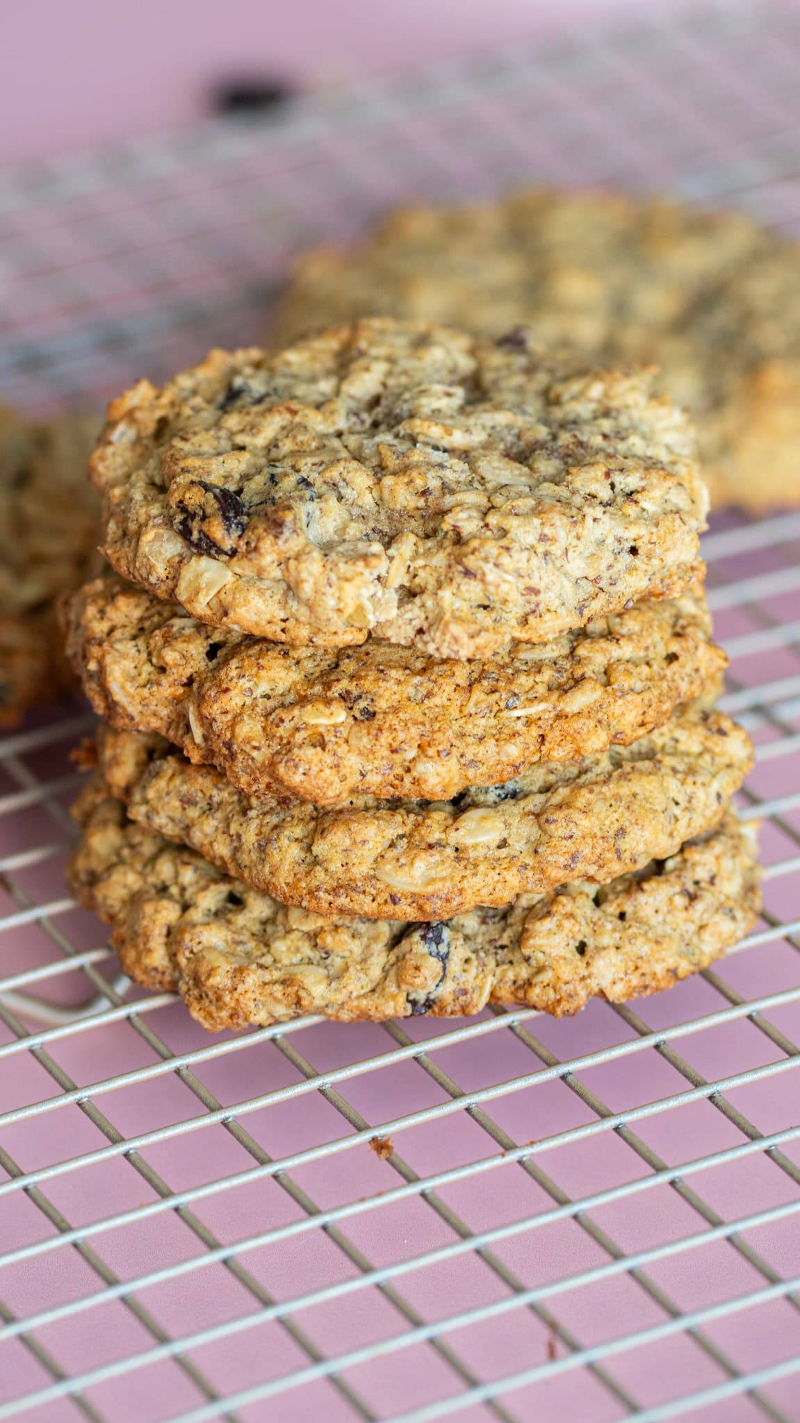 A stack of chewy oat cookies cooling on a wire rack